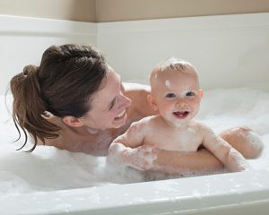 Mother and baby having bubble bath